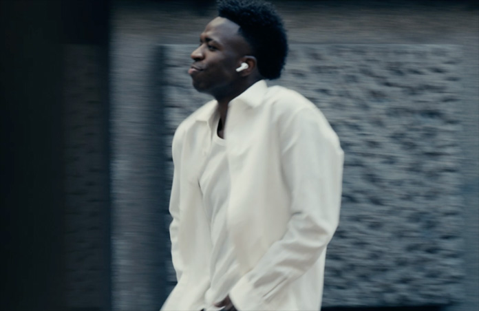 Una persona al aire libre con una camisa blanca, se ve el audífono izquierdo de los AirPods Pro 3