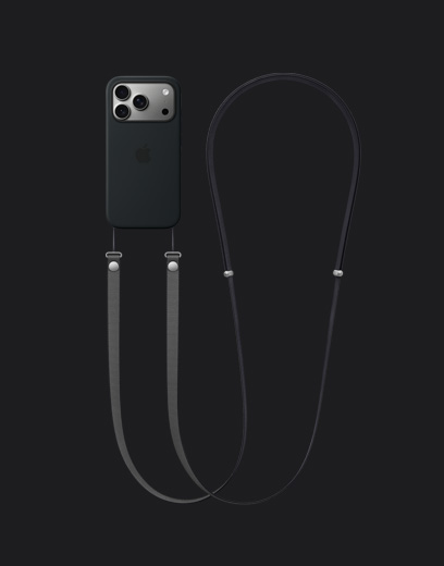 „iPhone 17 Pro“, galinės pusės dalis, sidabro spalvos, su juodos spalvos silikoniniu dėklu su „MagSafe“ ir pritvirtintu tamsiai pilkos spalvos „Crossbody Strap“ dirželiu per petį